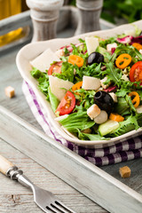 Italian salad with fresh vegetables with black olives and Parmesan cheese.