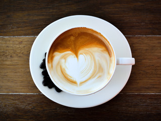 Coffee cup and coffee beans on old wooden background