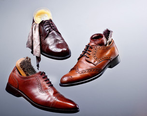 Fashion classical polished men's shades of brown oxford brogues.Shoe maintenance set glance shoescloth, brushes and wax for polishing shoes.Shoes care.Concept stages of shoes care.Copy space - Powered by Adobe