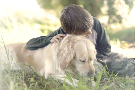 Small boy embracing sweetly his dog