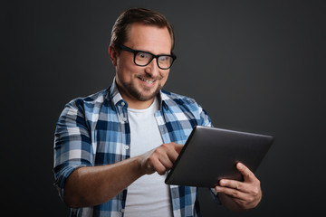 Focused positive man working with his gadget