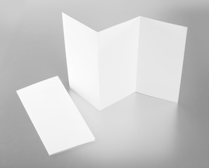 blank white folding paper flyer on silver background