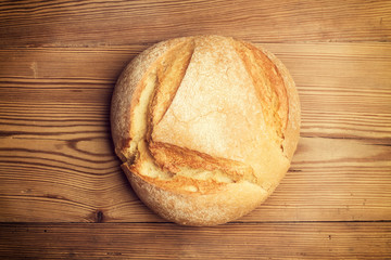 Pan redondo casero sobre fondo de madera rústica. Vista superior
