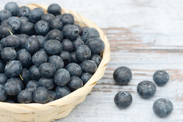 many blueberries in the basket  on wood