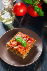 Piece of tasty hot lasagna with spinach on a plate