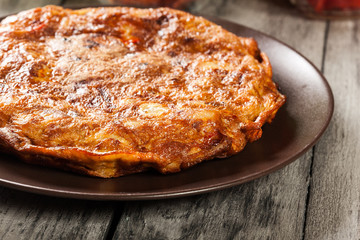 Tortilla de patatas. Spanish omelette with sausage chorizo, potatoes, paprika and egg, accompanied by olive oil