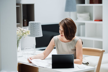 successful young woman with tablet sitting at the table