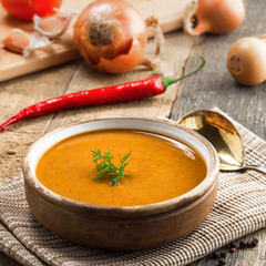 Bowl of delicious lentil soup with bread on an old wooden table. Traditional healthy vegetarian food for lunch.