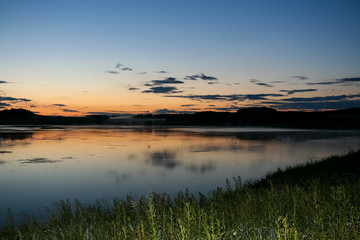 Summer landscape. Evening sky and river after sunset.