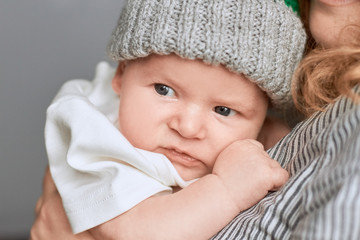 Woman holding child, close up. Face of caucasian infant.