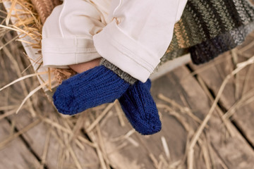Baby legs in socks. Blue knitted wool. Dressing your baby for winter.