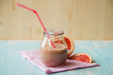 Grapefruit smoothie with ginger root and honey in a glass jar