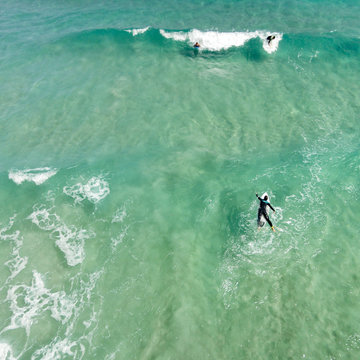Aerial view of surfers surfing in the ocean