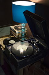 Old gramophone player and blue lamp on the little table, closeup