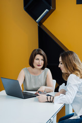 two girls with laptop at the table