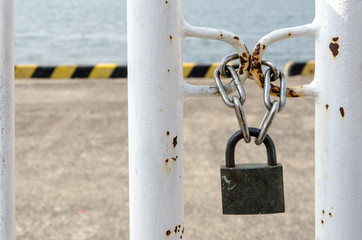 Key locked on chain front of the sea, meaning security, no entry, no freedom