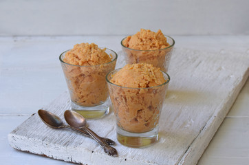 caramel ice cream in glass on light background. Copy space for text.