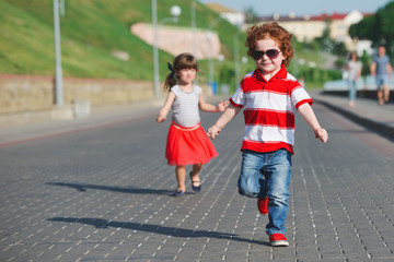 two happy children running on the promenade