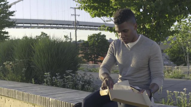 Man Texts, Puts Phone Down, Enjoys Pizza In The Park At Sunset