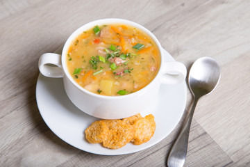 Peas soup with meat, smoked sausage and croutons. Selective focus