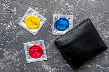 male contraception with condom and wallet on dark background top view