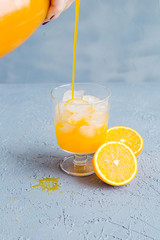 Fresh Orange Juice in Glass and Bottles and some Ripe Oranges on Grey Background. Healthy Drink, diet or Detox. © shutnica