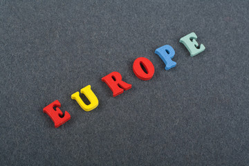EUROPE word on black board background composed from colorful abc alphabet block wooden letters, copy space for ad text. Learning english concept.