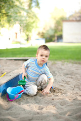 Two cute little children brother and sister playing in a sandbox