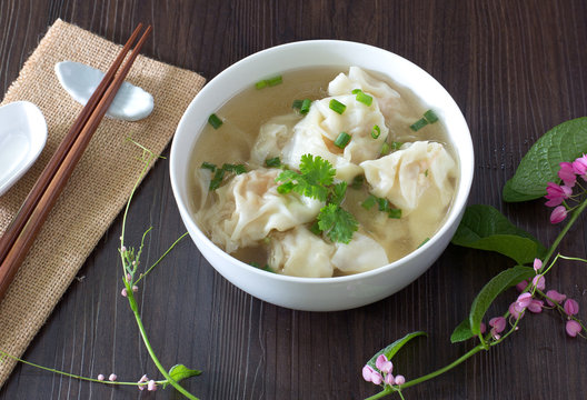 Shrimp wonton with braised pork in soup on wooden table / Select focus image.Shrimp wonton with braised pork in soup on wooden table / Select focus image..