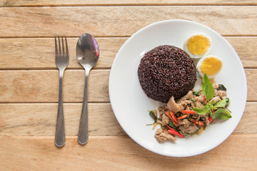 Spicy fried pork with basil leaves and boiled egg  Served with riceberry rice,Thai style food