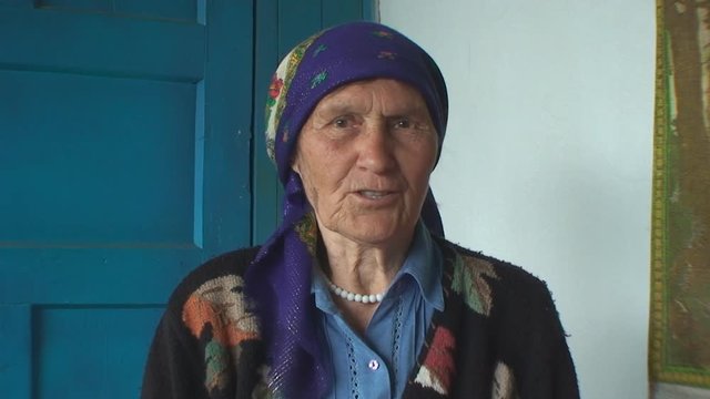 the elderly woman in a colorful headscarf