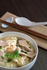 Shrimp wonton with braised pork in soup on wooden table / Select focus image ..
