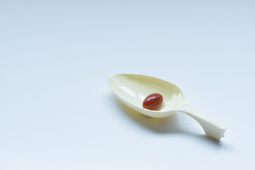 Medicine pills on spoon with white background, isolated.