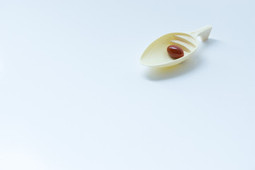 Medicine pills on spoon with white background, isolated.