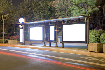 Blank bus stop advertising billboard in the city at night