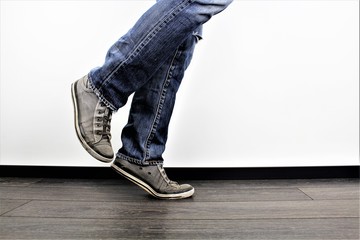 Man walking from right to left, casual clothing, people shot in indoors studio.