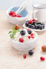 Cottage cheese with fresh berries, and nuts, fresh berries for breakfast on marble table, close up .