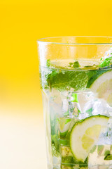Mojito cocktail in glass on yellow background
