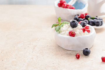 Cottage cheese with fresh berries, and nuts, fresh berries for breakfast on marble table, close up .