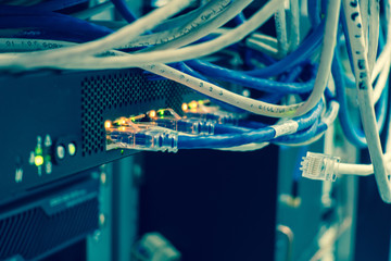 Close up of network internet cables, patch cords connected to black switch router in data center...