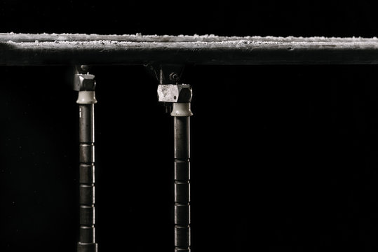 Closeup. Talcium powder over gymnastic parallel bars. Gymnastic parallel bars. Isolated on black background with fog,