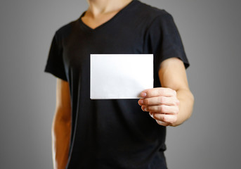 Man in a black shirt holding a white sheet of paper. Empty flyer. Isolated