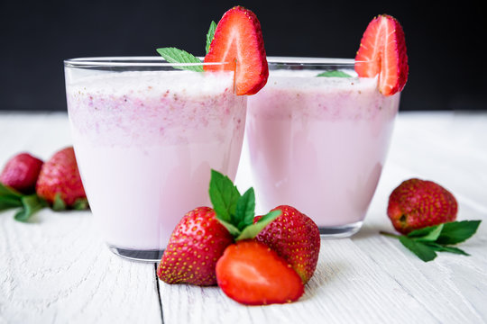 Strawberry smoothie with on wooden background. Fresh milkshake with berries