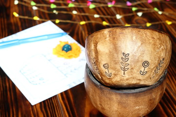 Naklejka na ściany i meble Two ceramic pottery handmade bowl and card drawing in sketching and doodling style with blue pen and spring sprig on wooden background