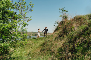 Naklejka na ściany i meble Bride and groom at wedding Day walking Outdoors
