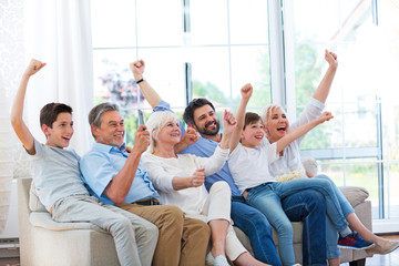 Excited family watching television on sofa
