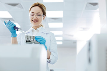 Positive delighted female scientist doing experiment