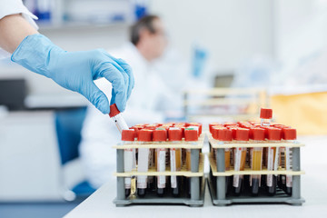 Male hand taking one test tube