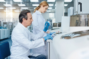 Serious technician doing blood analysis