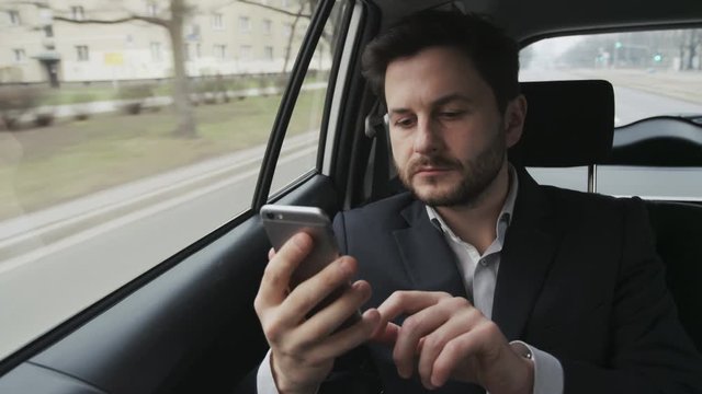 Young Businessman Using a Mobile Phone in the Car